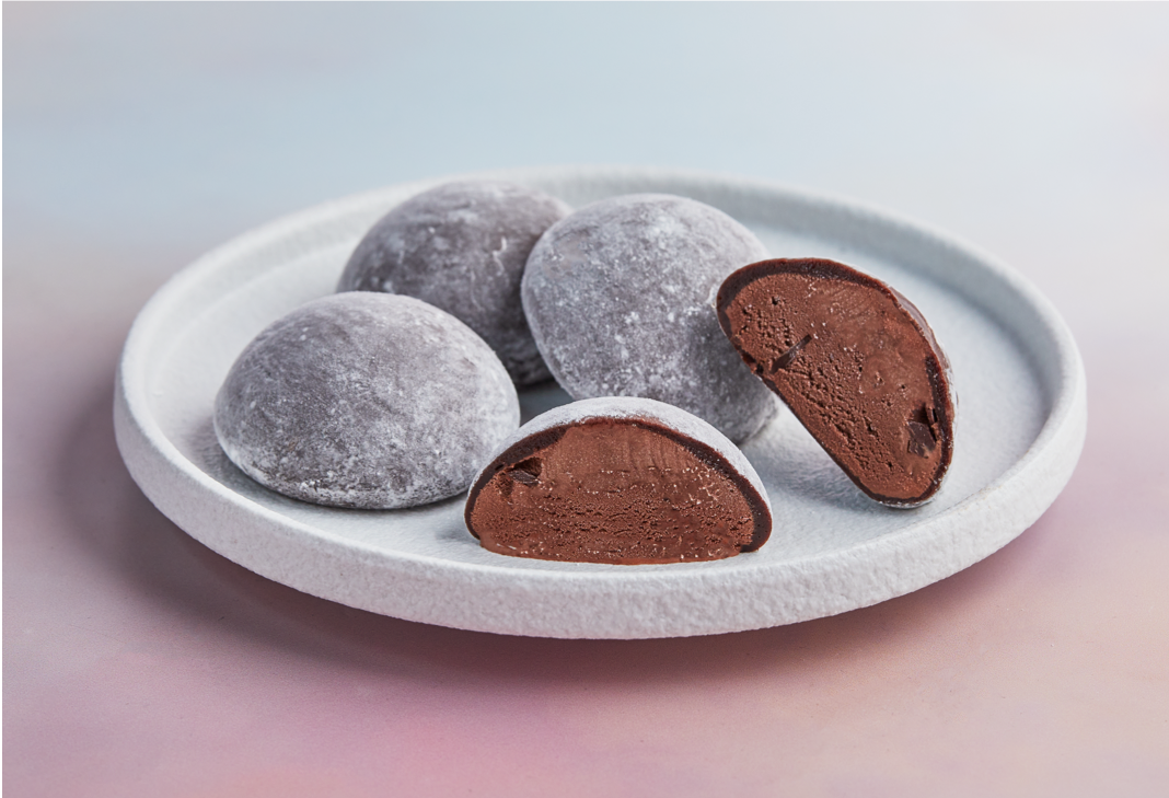 A white plate topped with 4 of pieces MOISHI Chocolate flavor mochi ice cream on the table