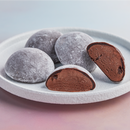 A white plate topped with 4 of pieces MOISHI Chocolate flavor mochi ice cream on the table