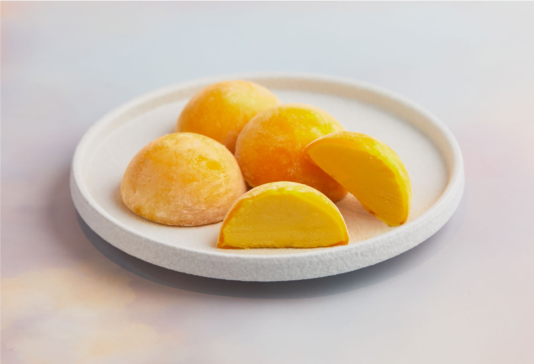 A white plate topped with pieces of mango flavored mochi ice cream from MOISHI Dubai's best mochi ice cream shop.