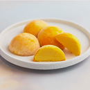 A white plate topped with pieces of mango flavored mochi ice cream from MOISHI Dubai's best mochi ice cream shop.