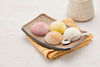 A plate of delicious mochi ice cream on a towel next to a vase- MOISHI, the best mochi ice cream brand in Dubai.